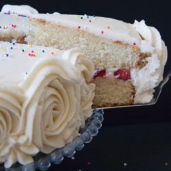 Moist and fluffy vanilla cake with strawberries and cream filling, surrounded with vanilla buttercream.