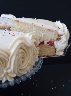 Moist and fluffy vanilla cake with strawberries and cream filling, surrounded with vanilla buttercream.