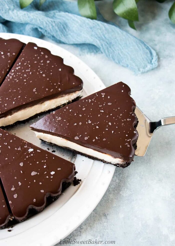 A chocolate ganache mascarpone tart with one slice being removed.