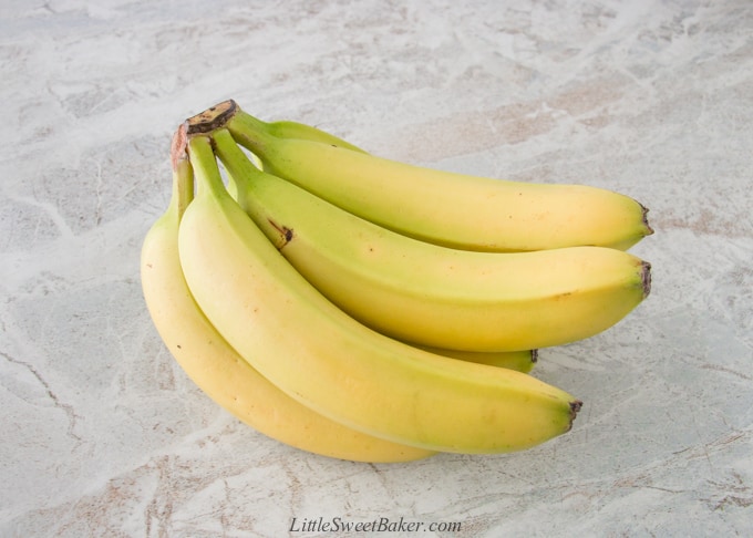 A yellow-green bunch of bananas on marble.