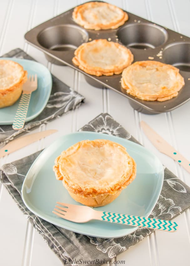 Two mini turkey pot pies on a plate and three mini turkey pot pies in a jumbo muffin pan.