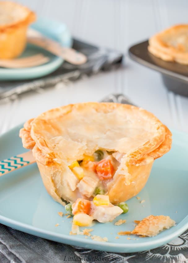 A mini turkey pot pie on a teal plate and grey napkin.