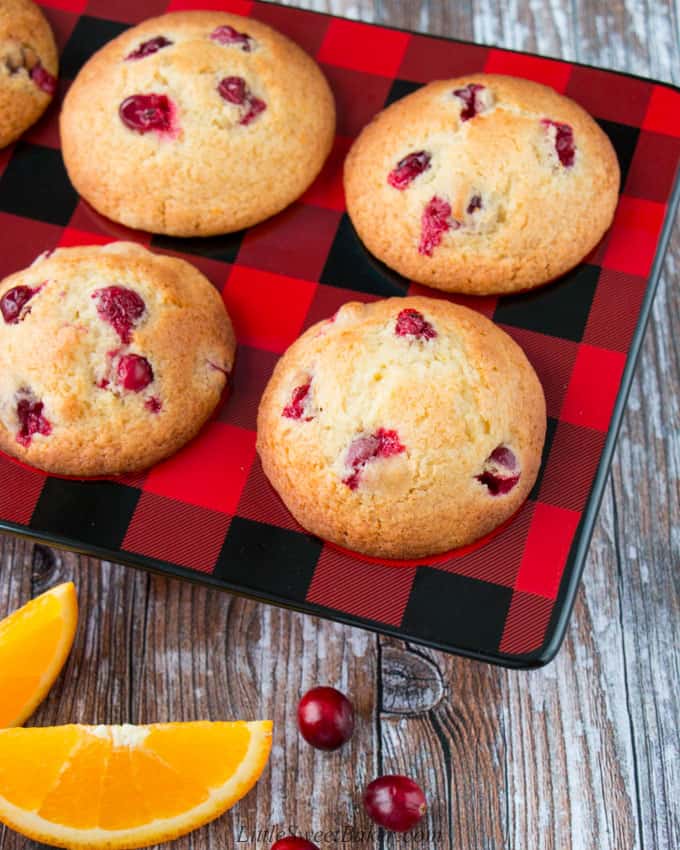 cranberry orange muffins in a red and black ceramic muffin pan