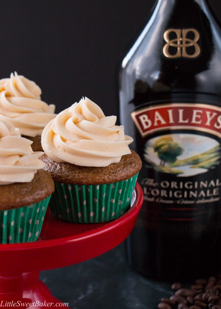 Baileys and coffee cupcakes on a red stand with a bottle of Baileys