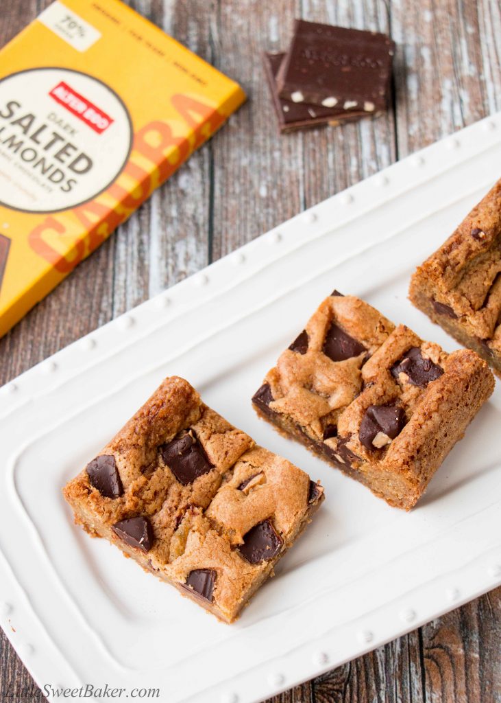 These chewy chocolate chunk cookie bars are so much easier to make than cookies. One bowl, one pan and done! #chocolatechipcookiebars #cookiebars #christmascookies #chocolatechunkcookies #chocolatechunkcookiebars