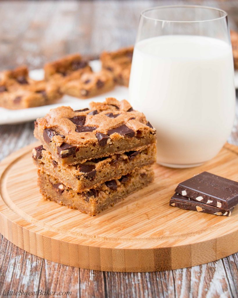 These chewy chocolate chunk cookie bars are so much easier to make than cookies. One bowl, one pan and done! #chocolatechipcookiebars #cookiebars #christmascookies #chocolatechunkcookies #chocolatechunkcookiebars