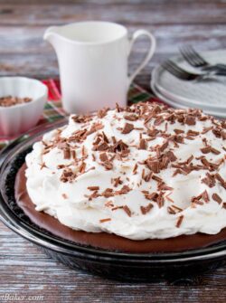 This chocolate pudding pie is made with a rich and silky homemade pudding over a chocolate cookie crust. It's topped with billowy clouds of whipped cream and sprinkled with chocolate shavings. #chocolatepuddingpie #easychocolatepuddingpie #bestchocolatepuddingpie #Thanksgivingdesserts #AD #milkcalendar