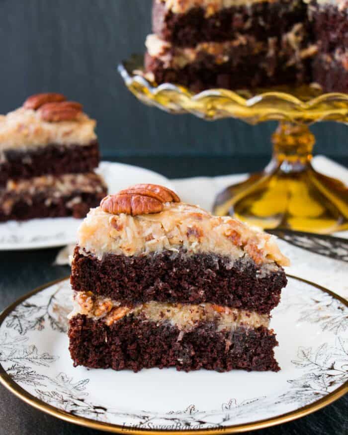 A slice of German chocolate cake on a white and gold plate.