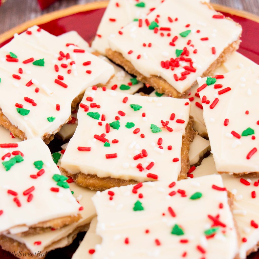 A close up of white chocolate Christmas crack on a red plate.