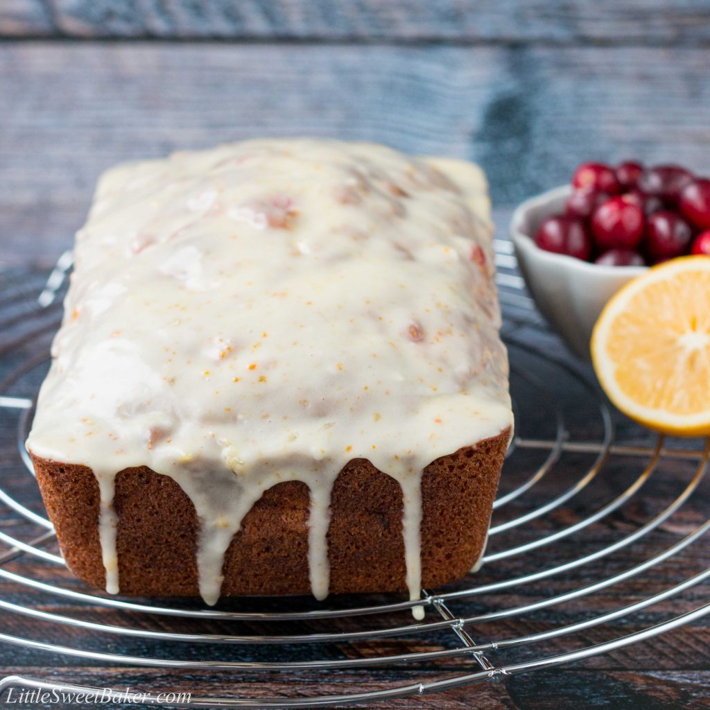 A soft and moist citrus flavored bread dotted with bright tart cranberries and topped with a sweet vibrant glaze! #cranberrybread #cranberryorangebread #orangebread #cranberrysweetbread