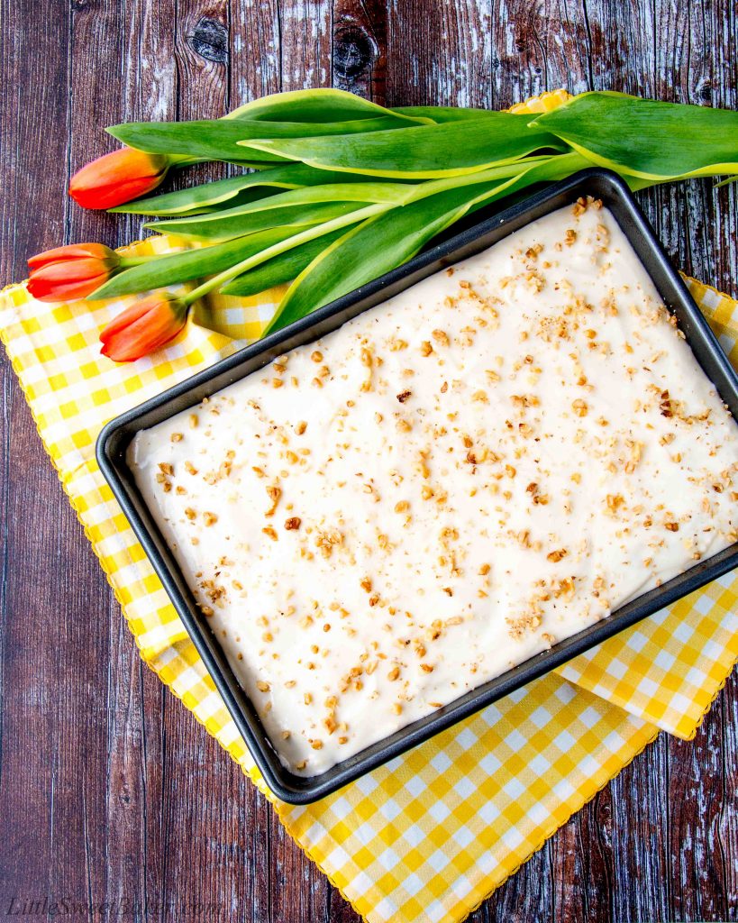 This delicious carrot cake is easy to make, moist and tender. It's speckled with shredded carrots, pineapple chunks, walnuts and topped with a sweet-tangy cream cheese frosting. #carrotcake #carrotcakerecipe #easycarrotcake