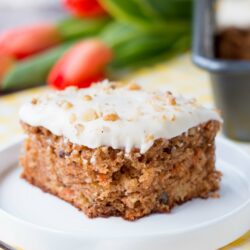 This delicious carrot cake is easy to make, moist and tender. It's speckled with shredded carrots, pineapple chunks, walnuts and topped with a sweet-tangy cream cheese frosting. #carrotcake #carrotcakerecipe #easycarrotcake