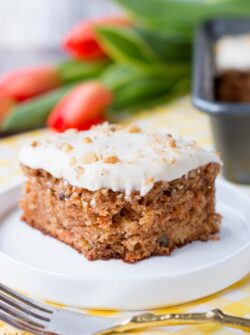 This delicious carrot cake is easy to make, moist and tender. It's speckled with shredded carrots, pineapple chunks, walnuts and topped with a sweet-tangy cream cheese frosting. #carrotcake #carrotcakerecipe #easycarrotcake