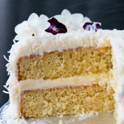 This delicious made-from-scratch coconut cake is infused with natural coconut flavor and topped with a sweet-tangy cream cheese frosting. #coconutcake #southerncoconutcake #bestcoconutcake #inagartencoconutcake #easycoconutcake #easterdessert