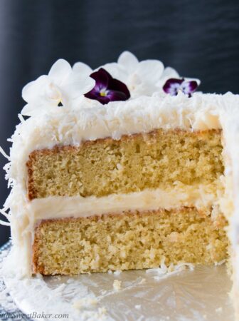 This delicious made-from-scratch coconut cake is infused with natural coconut flavor and topped with a sweet-tangy cream cheese frosting. #coconutcake #southerncoconutcake #bestcoconutcake #inagartencoconutcake #easycoconutcake #easterdessert