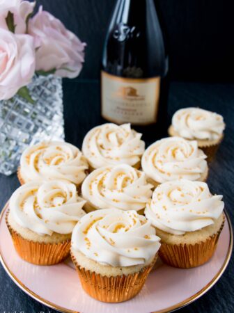 These cupcakes are rich, moist and full of champagne flavor. They are topped with a sweet and tangy champagne buttercream, and some gold sprinkles to make them extra special! #champagnecupcakes #champagnefrosting #mothersday #newyearseve #recipe #dessert