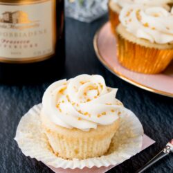 These cupcakes are rich, moist and full of champagne flavor. They are topped with a sweet and tangy champagne buttercream, and some gold sprinkles to make them extra special! #champagnecupcakes #champagnefrosting #mothersday #newyearseve #recipe #dessert