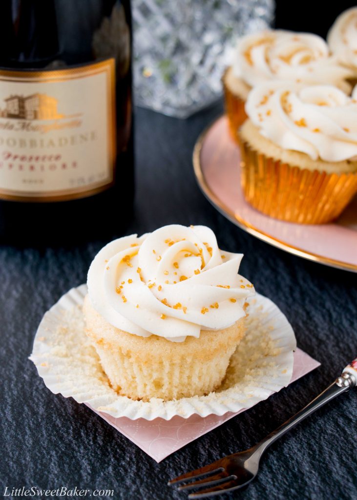 These cupcakes are rich, moist and full of champagne flavor. They are topped with a sweet and tangy champagne buttercream, and some gold sprinkles to make them extra special! #champagnecupcakes #champagnefrosting #mothersday #newyearseve #recipe #dessert