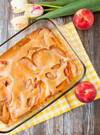 This heavenly peach cobbler consists of juicy flavorful peaches baked underneath a soft and fluffy cake topping. You can enjoy this made-from-scratch recipe all year round by using fresh, canned or even frozen peaches! #peachcobbler #easypeachcobbler #southernpeachcobbler