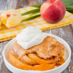 This heavenly peach cobbler consists of juicy flavorful peaches baked underneath a soft and fluffy cake topping. You can enjoy this made-from-scratch recipe all year round by using fresh, canned or even frozen peaches! #peachcobbler #easypeachcobbler #southernpeachcobbler