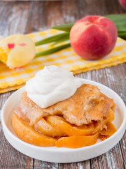 This heavenly peach cobbler consists of juicy flavorful peaches baked underneath a soft and fluffy cake topping. You can enjoy this made-from-scratch recipe all year round by using fresh, canned or even frozen peaches! #peachcobbler #easypeachcobbler #southernpeachcobbler