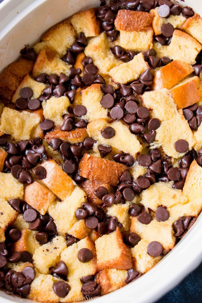 Chocolate chip bread pudding made with brioche in a white casserole dish.