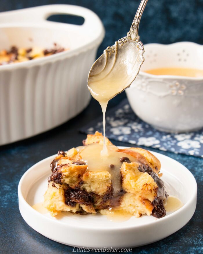 Bread pudding with bourbon sauce on a white plate