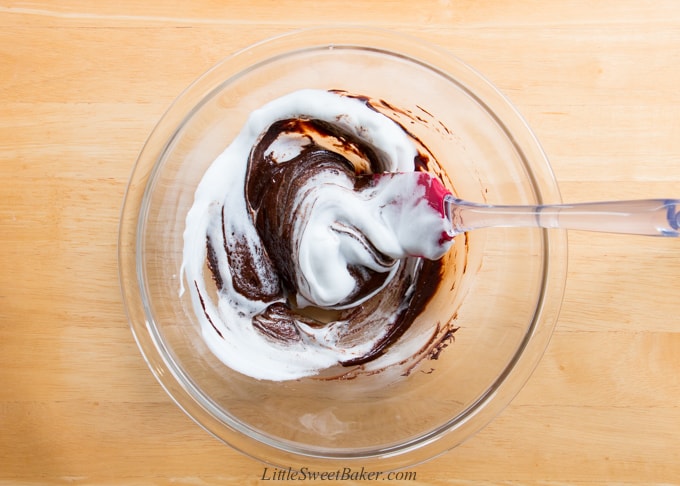 combining beaten egg whites with a chocolate mixture to make souffle