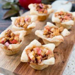 A cross between sweet and savory, these apple tartlets are wrapped in a flaky puff pastry and filled with apples, creamy brie and walnuts. #appletartlets #miniappletarts #appleandcheese #appetizer #snack