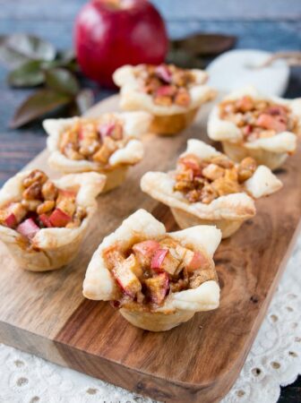 A cross between sweet and savory, these apple tartlets are wrapped in a flaky puff pastry and filled with apples, creamy brie and walnuts. #appletartlets #miniappletarts #appleandcheese #appetizer #snack