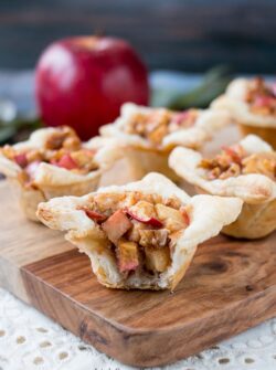 A cross between sweet and savory, these apple tartlets are wrapped in a flaky puff pastry and filled with apples, creamy brie and walnuts. #appletartlets #miniappletarts #appleandcheese #appetizer #snack