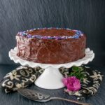 This supremely moist and tender chocolate cake is surrounded by a rich chocolate fudge frosting. It's the best chocolate cake you'll ever taste and uber easy to make! #chocolatecake #chocolatefudgecake #chocolatelayercake
