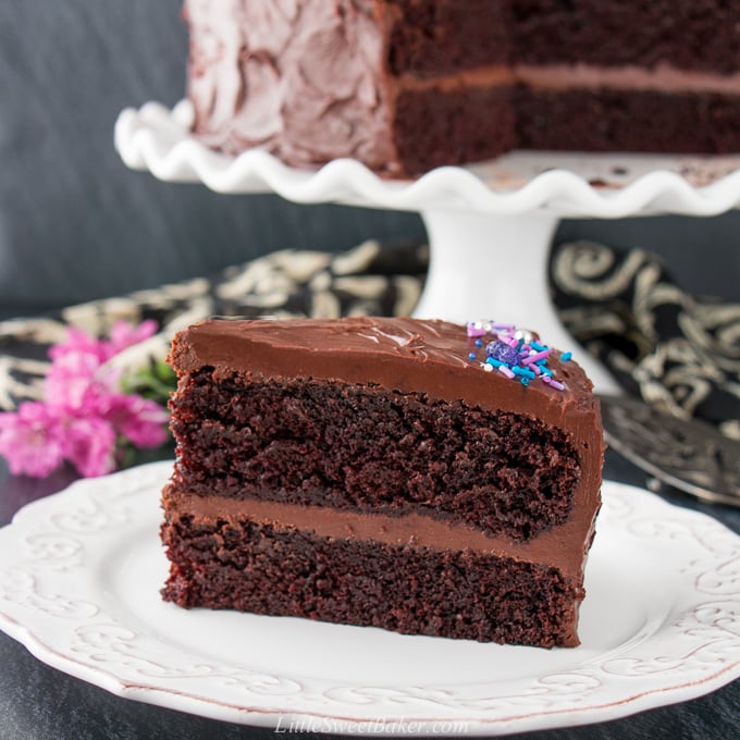 This supremely moist and tender chocolate cake is surrounded by a rich chocolate fudge frosting. It's the best chocolate cake you'll ever taste and uber easy to make! #chocolatecake #chocolatefudgecake #chocolatelayercake