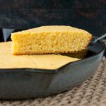 This one-bowl recipe for tender and buttery cornbread is baked in a cast iron skillet for a delightfully crispy crust. #cornbreadrecipe #skilletcornbread #buttermilkcornbread #castironcornbread
