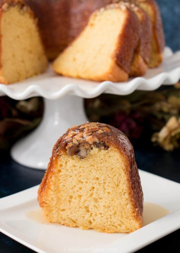 A slice of rum cake with warm rum sauce poured over top.