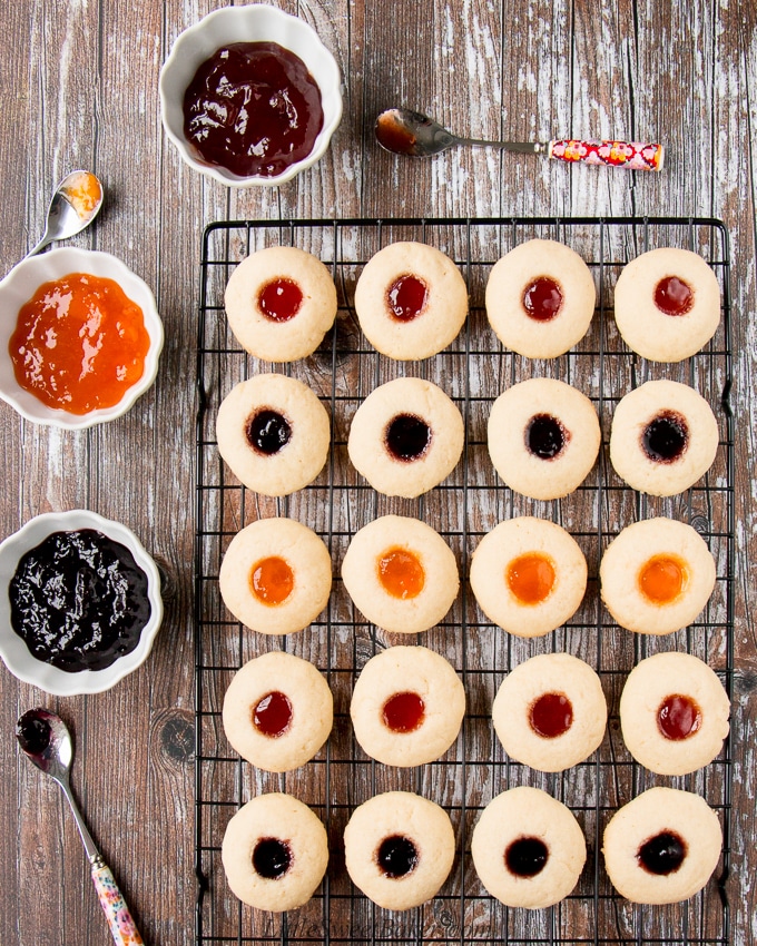 This classic holiday cookies is buttery and chewy with a delicious pocket of jam. #thumbprintcookies #Christmascookies #recipe #sugarcookie