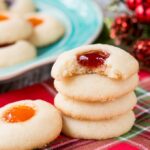 This classic holiday cookies is buttery and chewy with a delicious pocket of jam. #thumbprintcookies #Christmascookies #recipe #sugarcookie