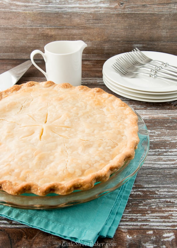 whole chicken pot pie in a glass plate on a teal napkin