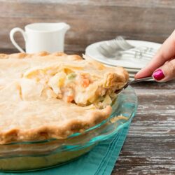 slice of chicken pot pie being lifted from whole pie
