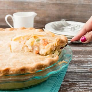 slice of chicken pot pie being lifted from whole pie