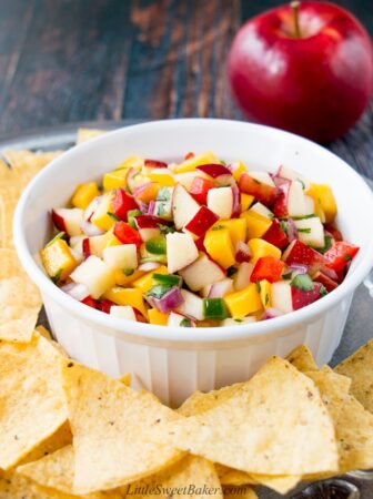 apple mango salsa in a white bowl surrounded by tortilla chips