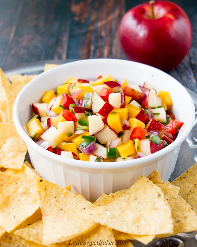 apple mango salsa in a white bowl surrounded by tortilla chips
