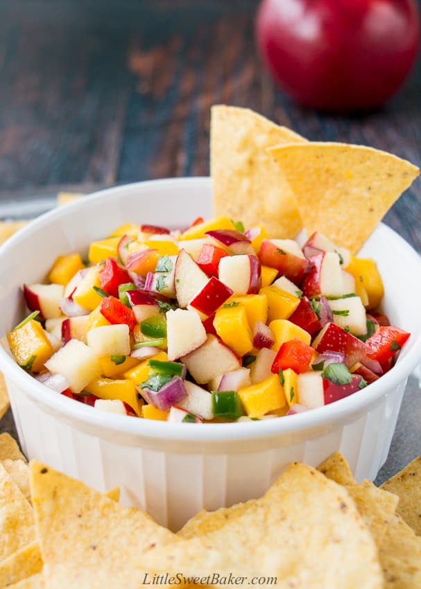apple mango salsa in a white bowl surrounded by tortilla chips