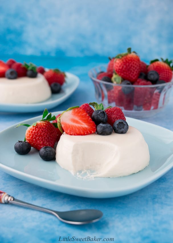 partially eaten panna cotta with berries on a blue plate