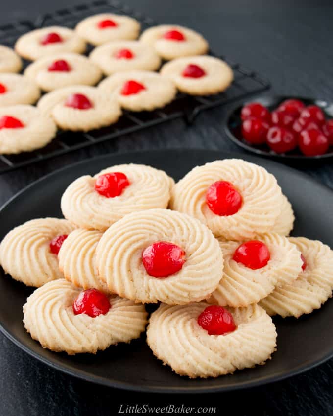 A plate of butter cookies with candied cherries.