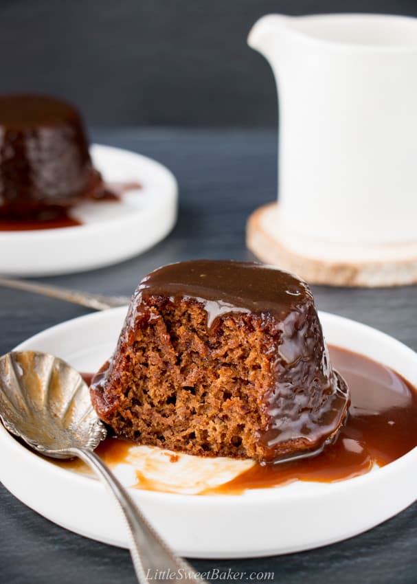 sticky toffee pudding on a white plate with a silver spoon