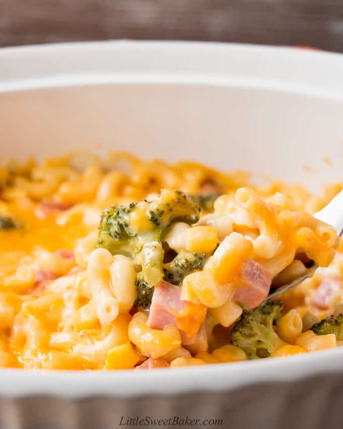 A scoop of leftover ham and vegetable casserole in a white casserole dish.