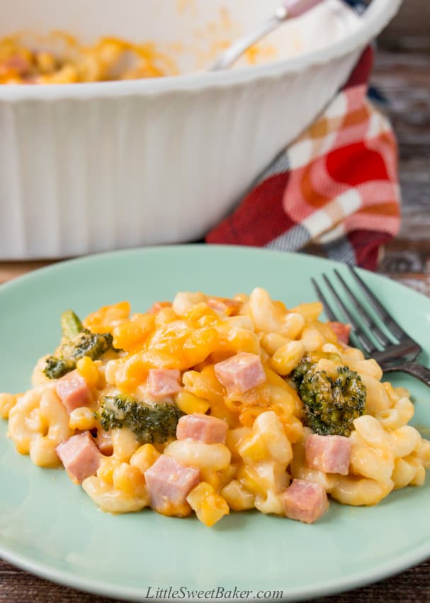 A green plate of leftover ham and vegetable casserole with a black fork.