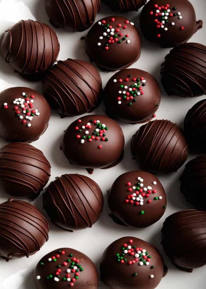 Chocolate-covered peanut butter closely scattered on a white surface.