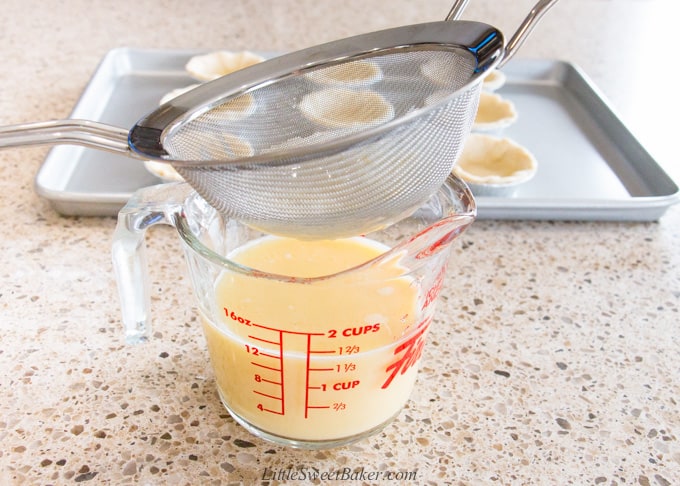 straining custard mixture through a fine mesh sieve